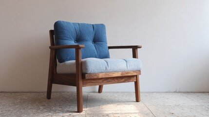 Wooden armchair with a blue cushion on it. the chair has a modern design with a low backrest and armrests. the seat and backrest are upholstered in a light blue fabric with a tufted design.