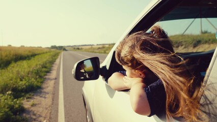 little child kid daughter childhood girl dreamily stuck hand out window family car, feeling fresh breeze while traveling down road sunset, symbolizing carefree childhood family adventures. dream