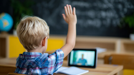 Rear view of a young schoolboy raising his hand during an online lesson on a tablet