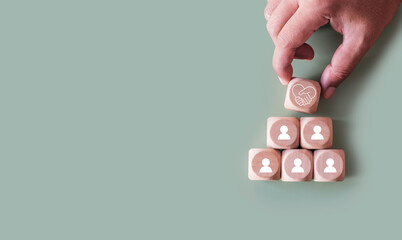 Hands holding wood cube with empathy leadership icon. symbolizing supportive management, trust...