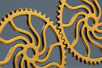 Teamwork and collaboration concept with two small gears interlocked on grey background