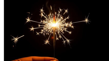Sparkling sparkler in hand glowing in the dark night sky