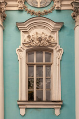 Baroque window with stucco decor on turquoise wall