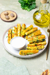 Crispy breaded zucchini sticks with white dipping sauce. Healthy eating. Vegetarian food.