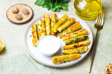 Crispy breaded zucchini sticks with white dipping sauce. Healthy eating. Vegetarian food.