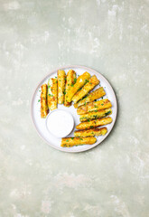 Crispy breaded zucchini sticks with white dipping sauce. Healthy eating. Vegetarian food.