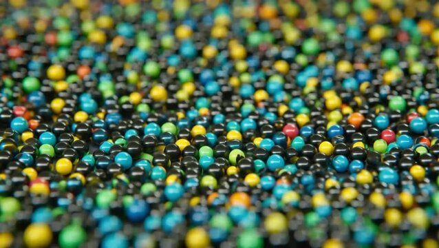 Colorful plastic beads background, vibrant small spheres texture, macro shot of multicolored craft supplies, abstract decorative round pellets