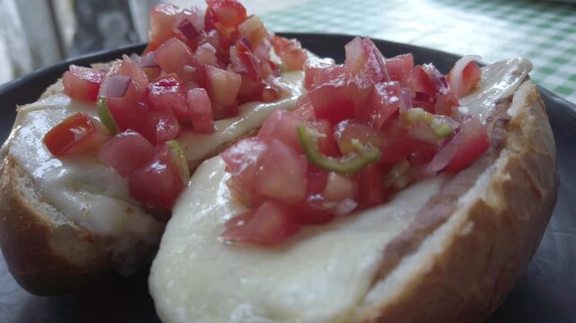 Molletes with melted cheese and fresh salsa on toasted bread