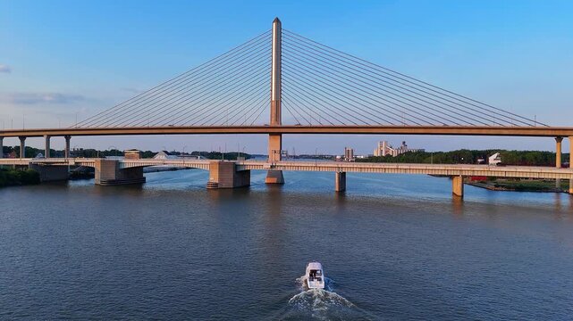 Craig Memorial Bridge crossing Maumee River in Toledo, Ohio with boat below at dusk in aerial view