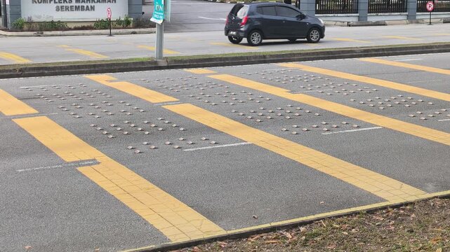 Yellow rumble strips are visible on the roadside. These safety features are installed to provide an auditory and tactile alert to drivers, promoting road awareness.