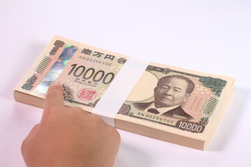 一万円札の3Dホログラムを指差す子どもの手