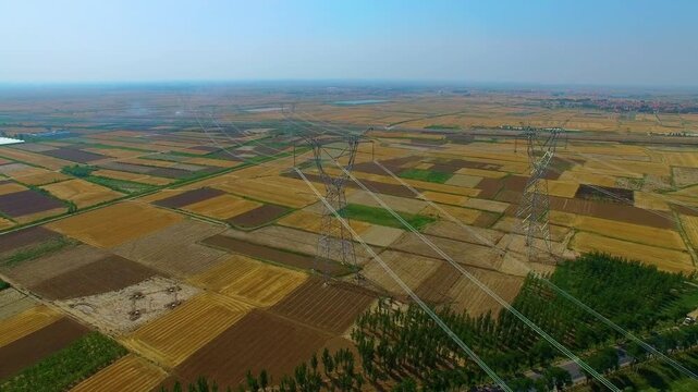High Voltage Transmission Towers Over Agricultural Farmland Aerial View