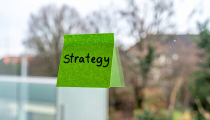 Green sticky note with handwritten strategy brainstorming marketing plan idea creativity note planning teamwork business idea for meeting