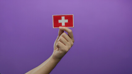 Man holding swiss flag embroidery against a vibrant purple background showcasing national pride and customization potential.