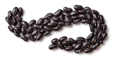 Obraz premium Close-up of black beans arranged in a curved, flowing shape on a white surface
