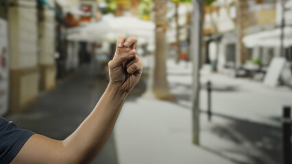 Man hand making gesture with blurred city street background creates intriguing scene of urban life...