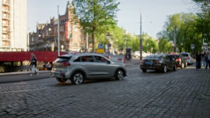 Defocused city street scene with blurred cars and pedestrians in a picturesque european urban area...
