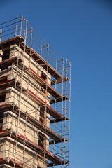A building with scaffolding on it and a blue sky in the background