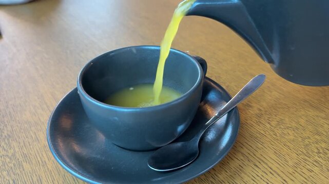 Green, freshly brewed hot tea is a delightful, invigorating beverage, poured into a glass.