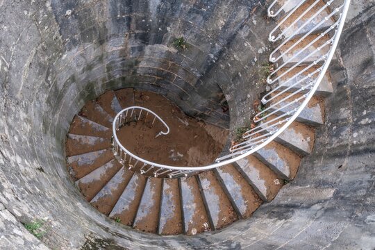 High Angle View of Old Spiral Stone Staircase with White Railing - Powered by Adobe