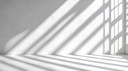 Obraz premium Soft window light casting long angled shadows across empty white floor and wall