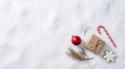 Christmas Flat Lay Composition on Snow with Gift, Ornament, and Cookie