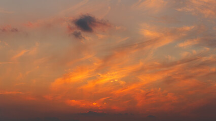 Vivid Orange Afterglow with Flowing Evening Clouds