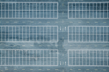 Top down aerial view of empty asphalt parking lot with white lines background. © zhao dongfang