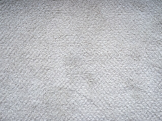 The textured surface of the carpet for floor light gray or off-white color. Close up