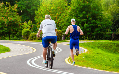 Obraz premium A man goes jogging in a summer park 