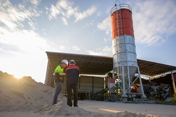 An engineer evaluating a concrete silo at an industrial facility with an emphasis on site planning for concrete production, safety, and structural condition.