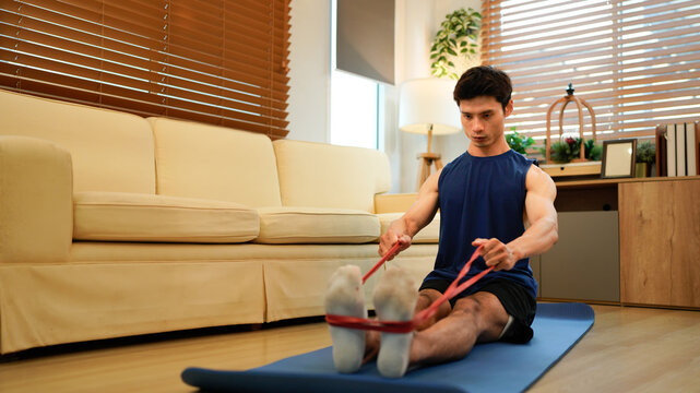 Man exercising with resistance band at home