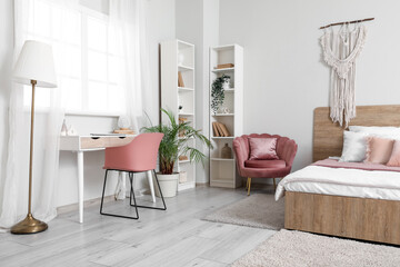 Cozy bed, comfortable armchair and workplace in bedroom