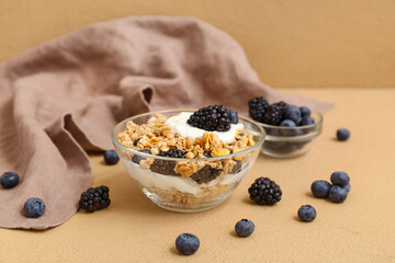 Bowls with tasty granola and berries on beige background