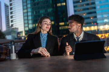Diverse business professionals discussing work outdoors in urban setting