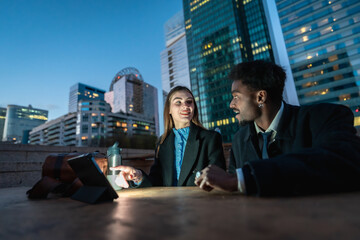 Business colleagues collaborating on tablet during an evening meeting
