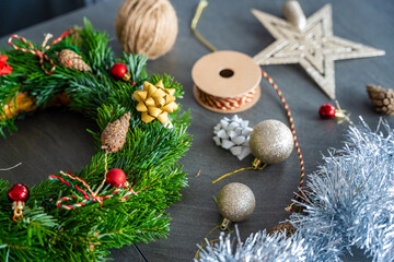 Top view of a fully decorated Christmas wreath surrounded by festive decor and crafting elements. A cozy handmade holiday creation made with care and creativity at home.