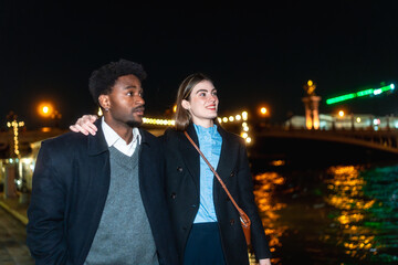 Young couple walking arm in arm during romantic city night