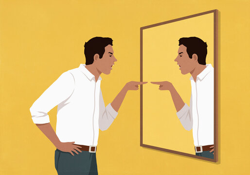 Angry man pointing and arguing at his reflection in mirror against yellow background
