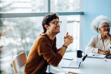 Smiling man and colleague discuss ideas in meeting