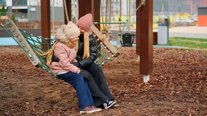 Mother and daughter sharing moment on swing