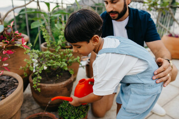 Father and son gardening together on a sunny day outdoors