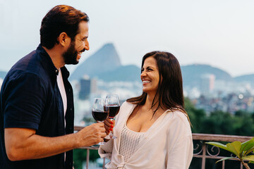 Couple enjoying red wine with Corcovado in the background during sunset