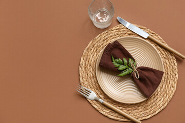 Beautiful table setting with fresh leaf on brown background