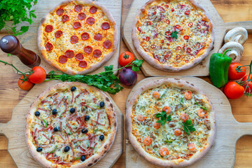 Assorted gourmet pizzas with various toppings displayed on wooden boards, showcasing vibrant colors and fresh ingredients for culinary delight