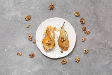 Plate of pear bruschetta with ricotta cheese and walnuts on grey background