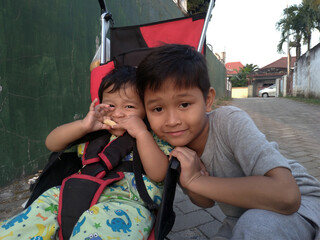Caring Sibling with Baby in Stroller