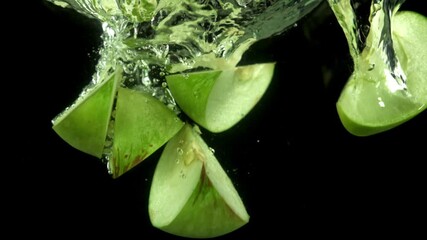 Pieces of green apples fall under the water. Filmed on a high-speed camera at 1000 fps. High quality FullHD footage - Powered by Adobe