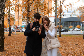 Happy Couple Reviewing Photos in Autumn Park