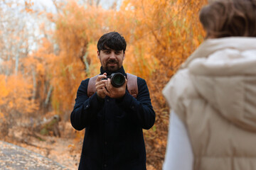 Couple Reviewing Camera Photos in Autumn Park
